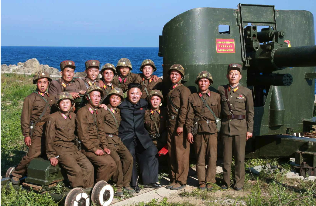 Kim Jong Un poses for a commemorative photo with service members of the Ung Islet Defense Detachment following an artillery training exercise (Photo: Rodong Sinmun).