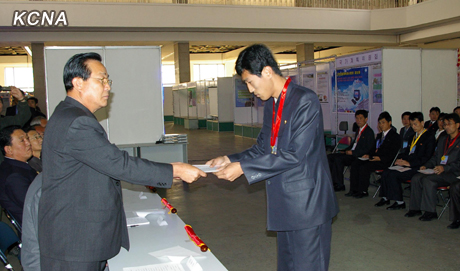 DPRK Vice Premier Kim Yong Jin (L) presents an award to a participant of the 23rd National Software Contest and Exhibition in Pyongyang on 25 October 2012 (Photo: KCNA)