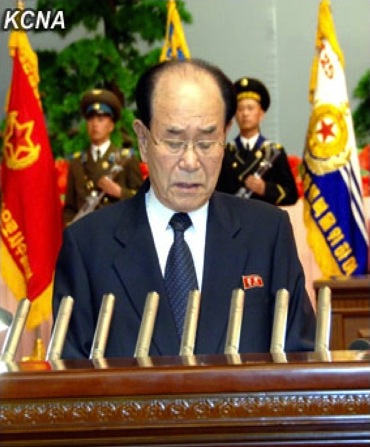 Kim Yong Nam, President of the SPA Presidium and Member of the KWP Political Bureau Presidium, reads the report at a national meeting marking Kim Jong Un's election as KWP 1st Secretary and NDC 1st Chairman (Photo: KCNA)
