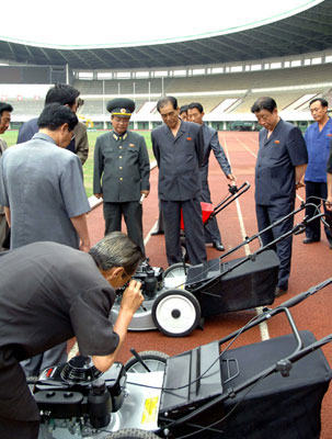 DPRK Cabinet Premier Pak Pong Ju (3rd R) inspects a lawn mower during his visit to the renovation of Yanggakdo Stadium in Pyongyang.  Also in attendance is DPRK Vice Premier and State Planning Commission Chairman Ro To Chol (2nd R) (Photo: Rodong Sinmun).