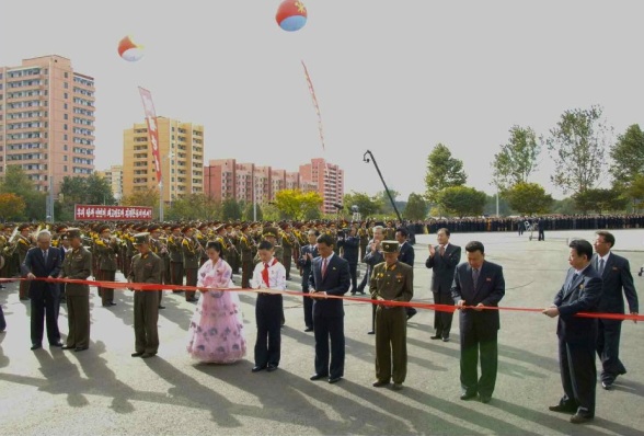 Senor DPRK officials hold a ceremonial red ribbon being cut by representatives of Pyongyang's population during a ceremony opening the Munsu Water Park in east Pyongyang on 15 October 2013 (Photo: Rodong Sinmun).