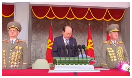 SPA Presidium President and WPK Political Bureau Presidium Member Kim Yong Nam delivers a speech prior to a May 10, 2016 parade celebrating the 7th Party Congress.  Also seen in attendance are WPK Political Bureau Members, Minister of State Security General Kim Won Wong and Chief of the KPA General Staff Vice Marshal Ri Myong Su (Photo: Korean Central TV).