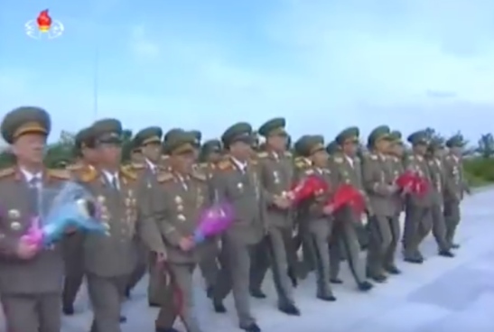 7th Party Congress participants bring floral bouquets to the stand at the entrance to Revolutionary Martyrs' Cemetery on May 4, 2016 (Photo: Korean Central TV).