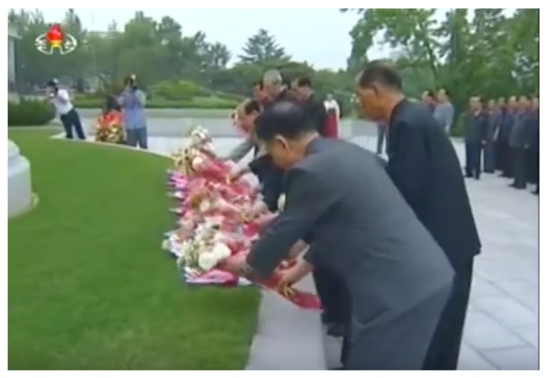 Members of the DPRK central leadership place floral bouquets in front of the KJI statue on the campus of Kim Il Sung University in Pyongyang on June 19, 2016 (Photo: Korean Central TV).