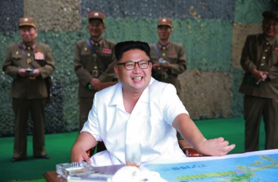 Kim Jong Un smiles during a ballistic missile drill in a photo that appeared on cover of the July 20, 2016 edition of the WPK daily newspaper Rodong Sinmun.  The man standing on the right appears to be WPK Munitions Industry Department Deputy Director Kim Jong Sik (Photo: Rodong Sinmun).